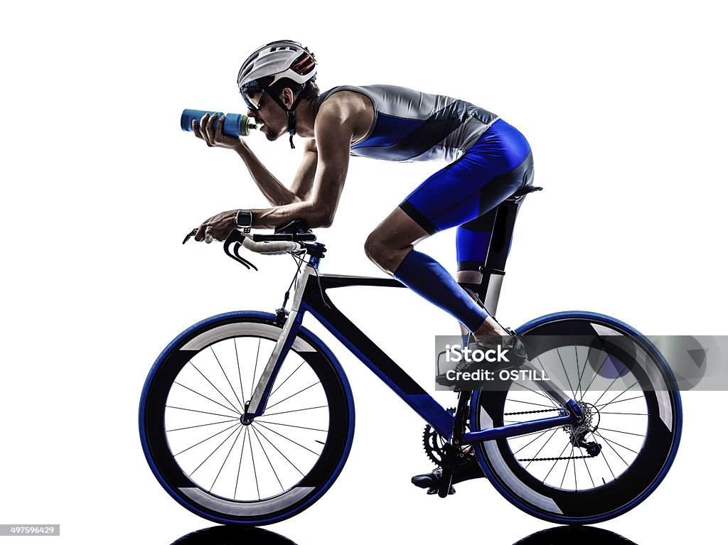 Iron man bicyclist drinking water while on bike man triathlon iron man athlete biker cyclist bicycling biking drinking in silhouette on white background Cycling Stock Photo