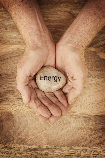 istock Energy Stone in Mature Hands on Wood Background 497600337