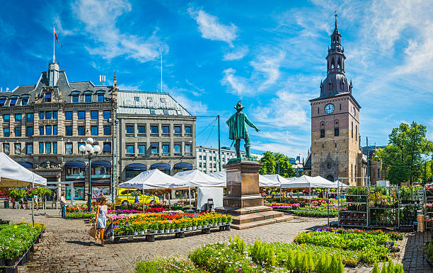 Oslo woman walking through flower market in square Stortovet Norway stock photo