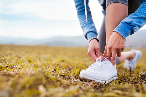 Close up of an unrecognizable young runner tying shoelaces