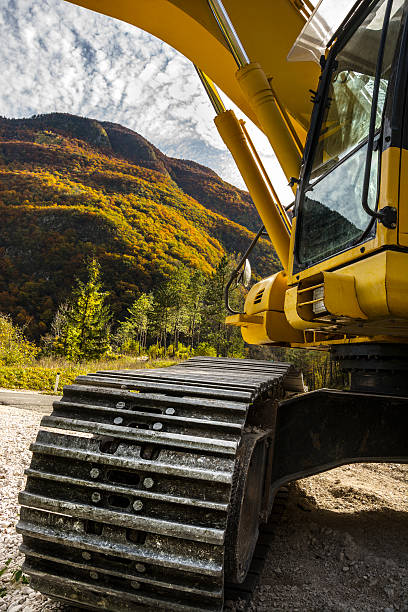 istock Heavy construction machinery (backhoe) in front of forest and sky 497606398