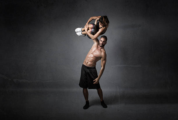 man lifting girl like a gym weight man lifting girl like a gym weight, darek background crossfit girl stock pictures, royalty-free photos & images