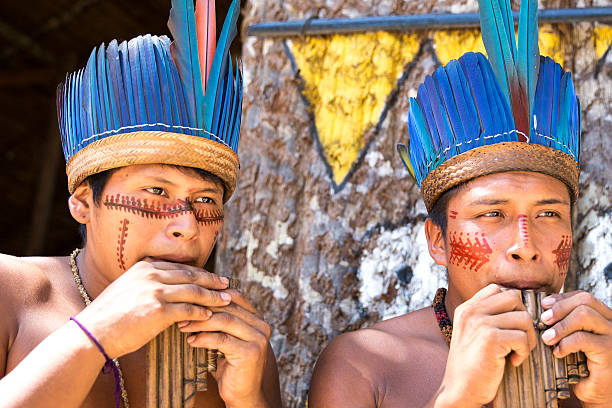 istock Native Brazilian guys playing wooden flute 497609272