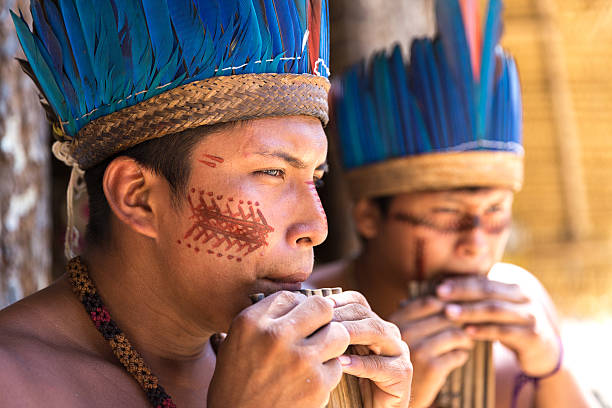 istock Native Brazilian guys playing wooden flute 497609802