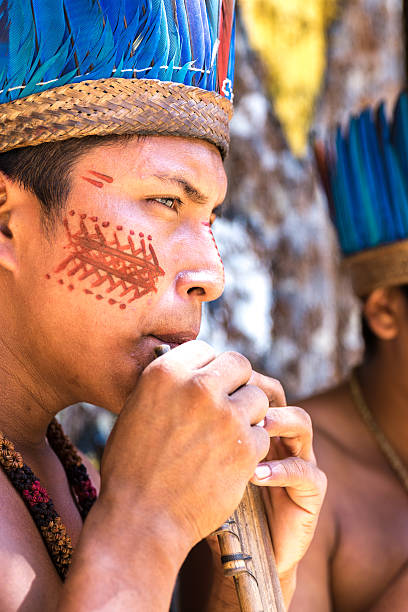 istock Native Brazilian guys playing wooden flute 497610908