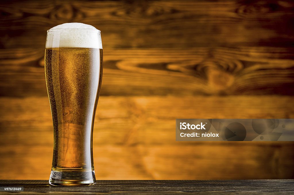 Glass of beer on wooden table and wooden background Alcohol Abuse Stock Photo