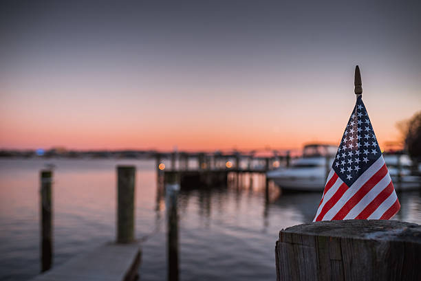 American Flag Sunset An American Flag pictured over the Potomac River looking towards Washington DC, picture taken in Alexandria, Virginia. marina photos stock pictures, royalty-free photos & images