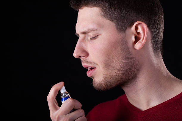 istock Man applying spray for sore throat 497617429