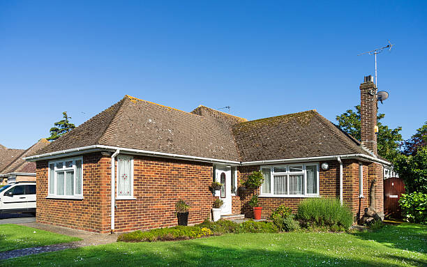 Residential bungalow home - UK A residential brick built bungalow home with a tiled roof built in 1955 and updated to include uPVC windows bungalow photos stock pictures, royalty-free photos & images