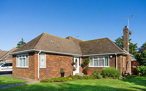 A residential brick built bungalow home with a tiled roof built in 1955 and updated to include uPVC windows