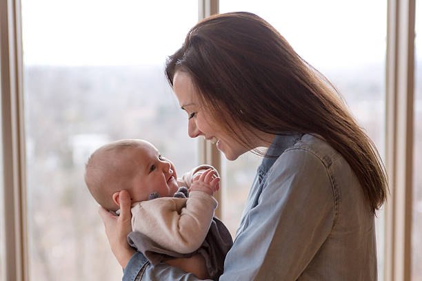 istock mother with her baby at home close to  window 497628534