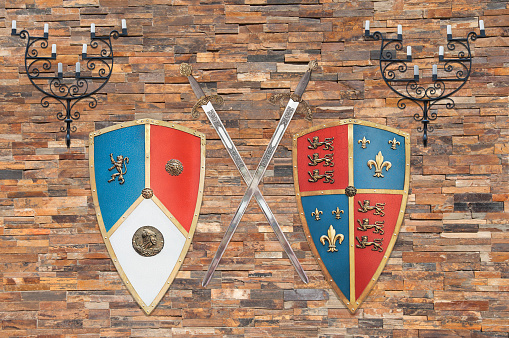 shields, swords and holders of the average age of the kingdom of Castile and Leon, Spain, are hanging on a brick wall