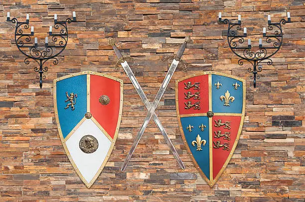 shields, swords and holders of the average age of the kingdom of Castile and Leon, Spain, are hanging on a brick wall