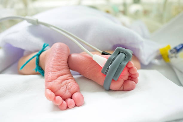 Baby feet and oxygen monitor baby feet and oxygen saturation monitor pulse oxymeter stock pictures, royalty-free photos & images