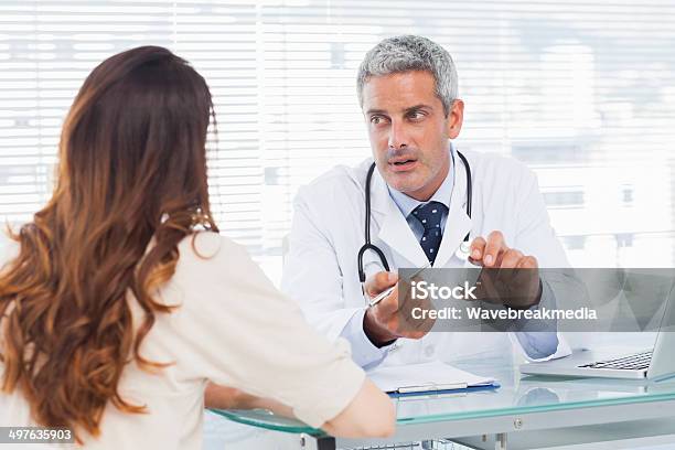 Doctor Talking With His Patient Seriously Stock Photo - Download Image Now - 30-39 Years, Adult, Asking