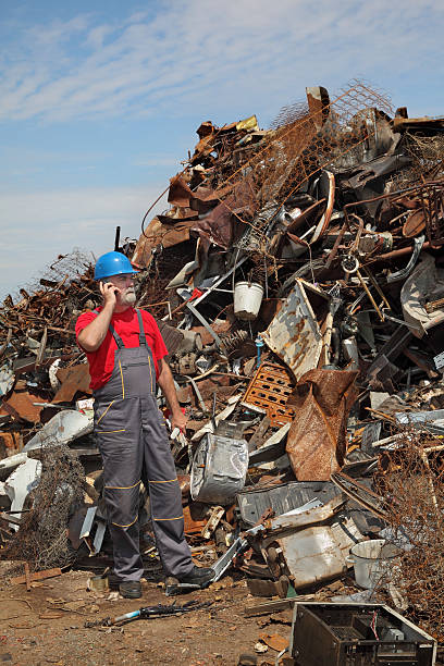 istock Recycling industry, worker using phone and heap of old metal 497636178