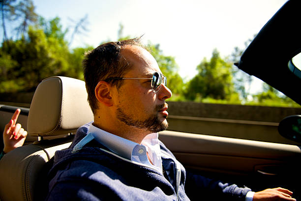 istock Young man driving cabriolet car 497636495