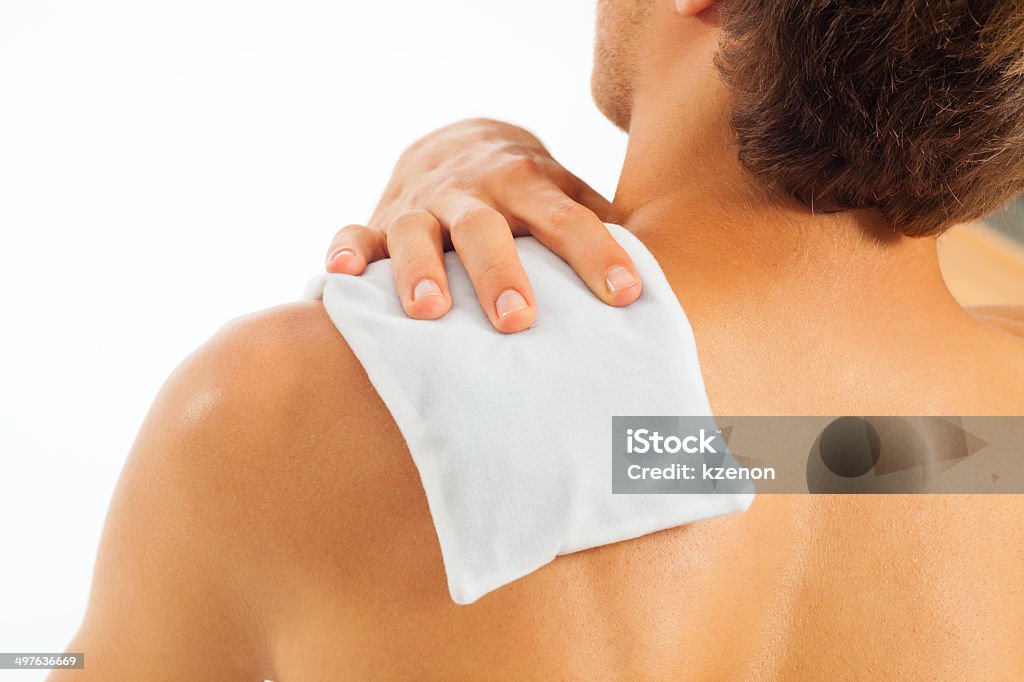 Young man with coolpack on his shoulder Young man with coolpack on his shoulder has a tension Alternative Therapy Stock Photo