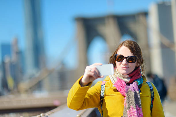istock Young woman taking a selfie on Brooklyn Bridge 497639536