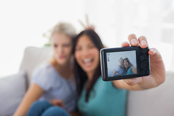 istock Two smiling friends taking photo with camera 497639659