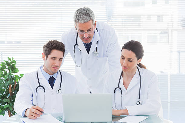 istock Team of concentrated doctors working together with their laptop 497640215