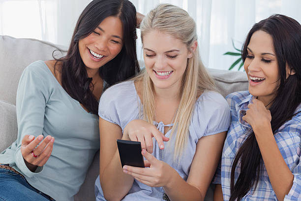 istock Laughing friends looking at smartphone 497640615