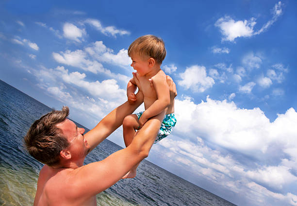 istock Son and father are at the beach in sunny day. 497641157