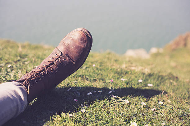Closeup on a foot wearing a boot by the sea