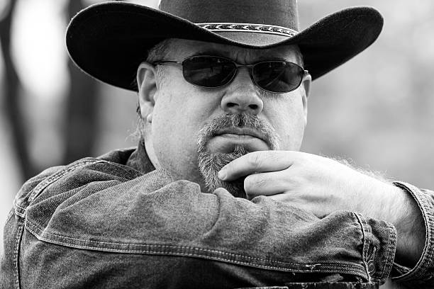 istock Black & White Image of Cowboy Touching Goetee With Finger 497651126