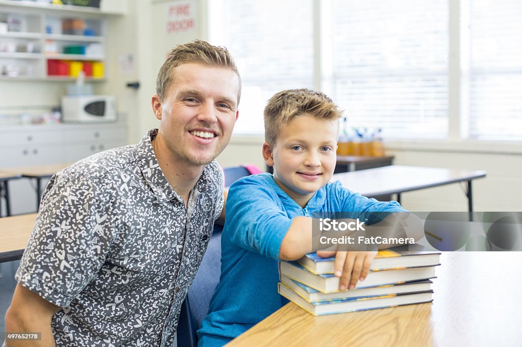 Male elementary teacher poses with student in classroom 2015 Stock Photo