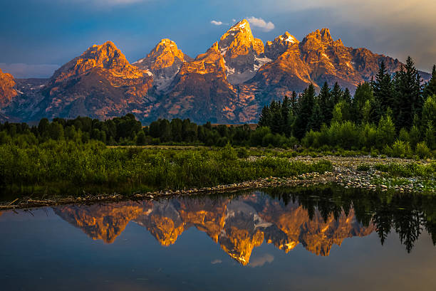Dramatic Grand Teton Sunrise The dramatic colors of the Grand Teton Mountains reflecting in the water on a clear summer morning. spectacular view stock pictures, royalty-free photos & images