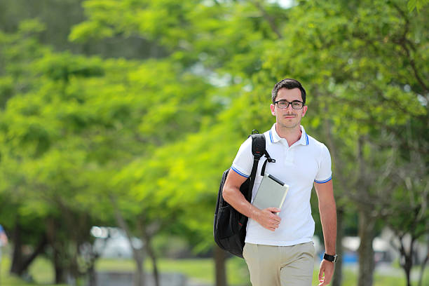 istock college student walking by at park 497654206