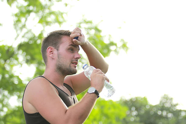 istock male runner wiping his sweat during break 497655650
