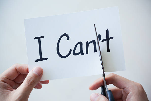 istock Using Scissors Cut Word on Paper Can't Become I Can 497657454
