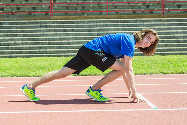 istock teen boy ready to run outside on a training field 497658184