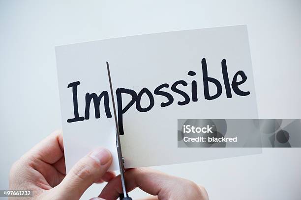 Using Scissors Cut The Word On Paper Impossible Become Possible Stock Photo - Download Image Now