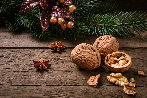 Anise, fir branch, cranberries and walnuts on wooden planks. You can use it for christmas background, card or voucher.