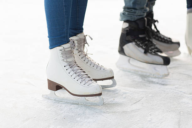 close up of legs in skates on skating rink people, winter sport and leisure concept - close up of legs in skates on skating rink skater feet stock pictures, royalty-free photos & images
