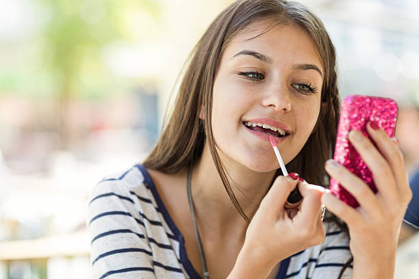 teen girl fijación su completar - red lipstick fotografías e imágenes de stock
