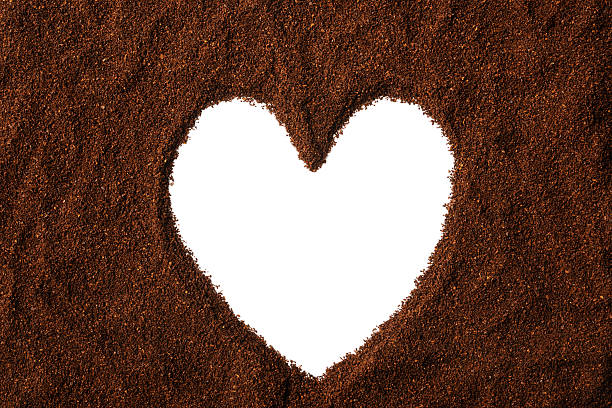 istock Heart shape frame of ground coffee beans on white background 497685185