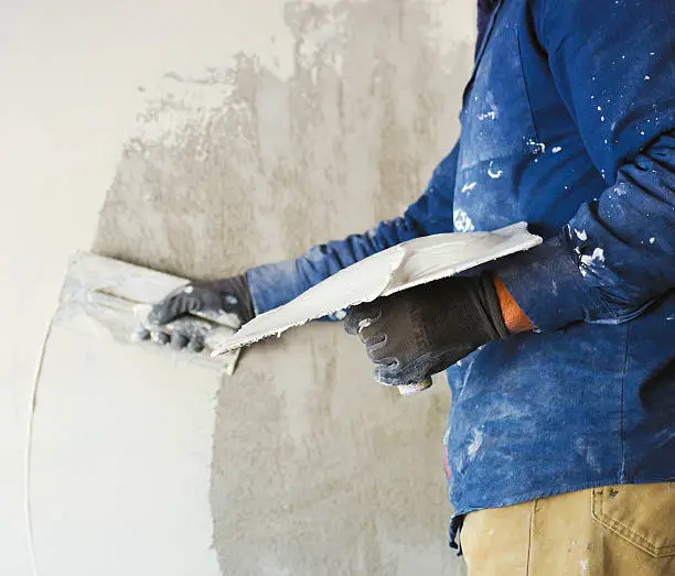 worker plastering tool plaster marble on interior plaster rough.  Selective focus