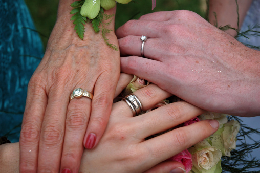 Bride, mother and grandmother showing hands with wedding ring
