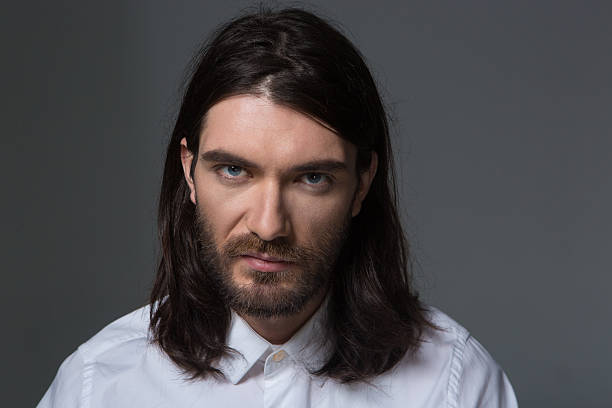 istock Serious man with beard and long hair looking at camera 497686924