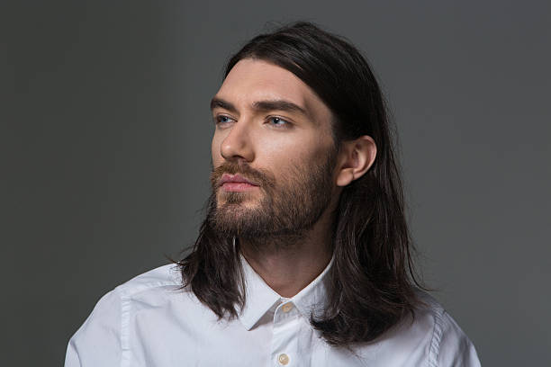 istock Serious man with beard and long hair looking away 497687358
