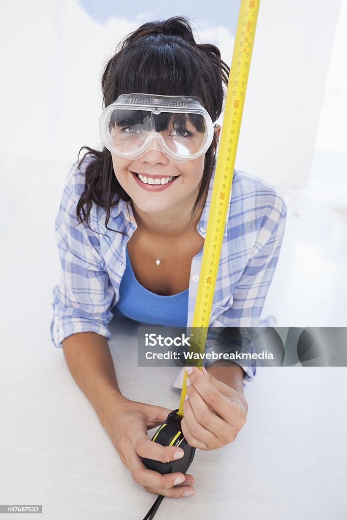 Happy woman lying on floor with measuring tape Happy woman lying on floor with measuring tape smiling at camera 20-29 Years Stock Photo