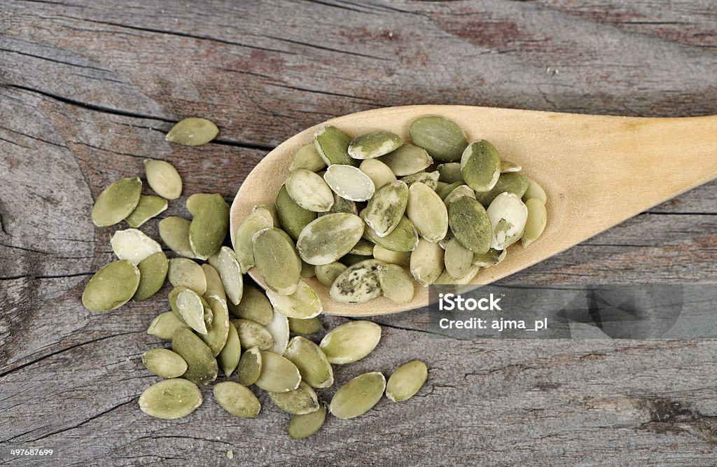 Pumpkin seeds in a wooden spoon. Pumpkin seeds in a wooden spoon. Top view. Close-up Stock Photo