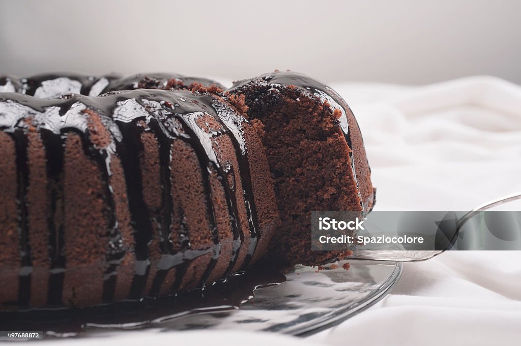 Chocolate cake Cutting a slice of chocolate cake with silver cutlery on white backgrounds Chocolate Cake Stock Photo