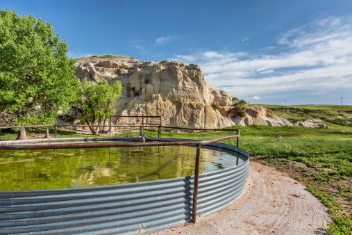 cattle water tank and rock cliff,  Pawnee Grassland in northern Colorado