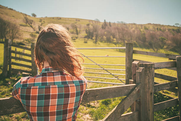 istock Young woman by a fence on a ranch 497690373