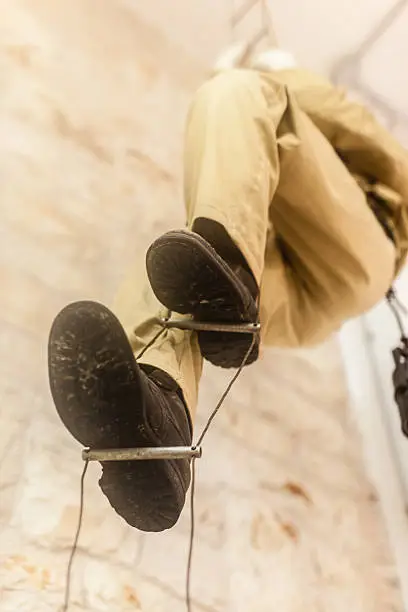 an old fashioned caver climbing up a rope ladder